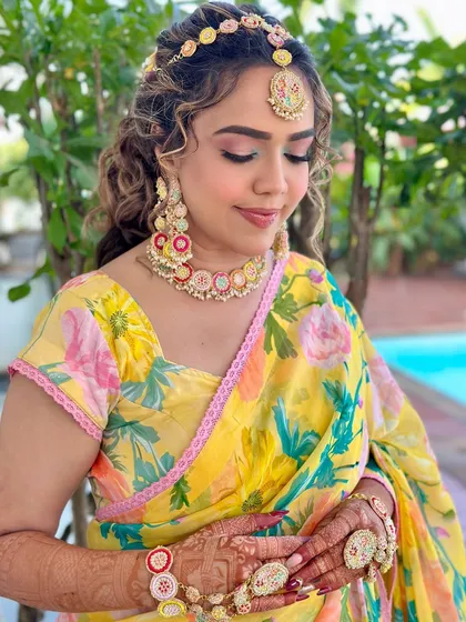 A beautiful portrait showcasing the pink and yellow tones in her makeup, which perfectly match her floral saree and jewelry.