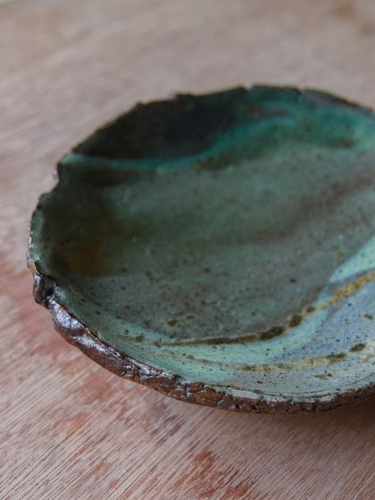 A small, rustic platter with a beautiful, flowing glaze pattern, created by letting go of expectations and embracing curiosity.