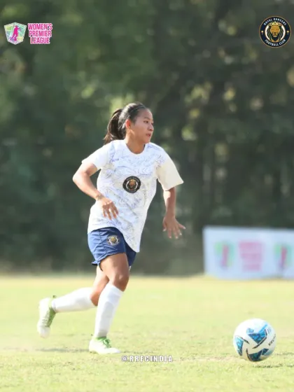 Our player scans the field while on the move, demonstrating awareness and vision as she advances with the ball.