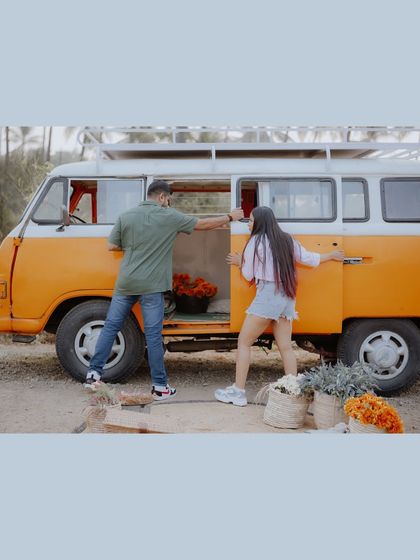 The groom helps the bride into the vintage van, a candid moment that sets the scene for their adventure-themed shoot.