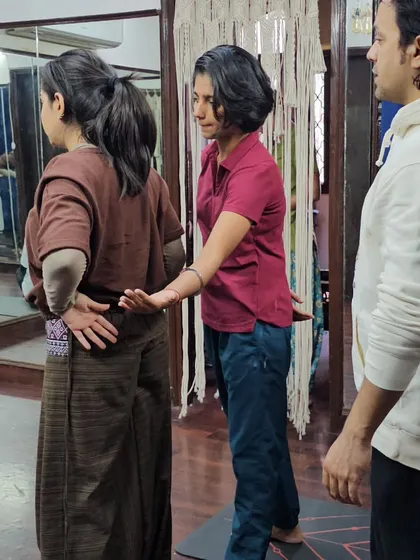An alignment and adjustment workshop during our TTC. Here, I'm guiding a student on how to properly adjust another in Tadasana (Mountain Pose) to teach correct posture.