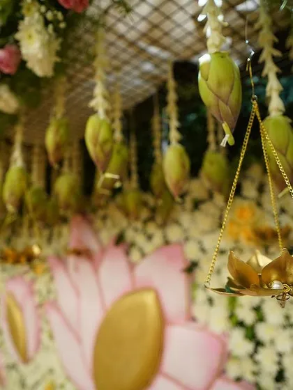 A close-up of the hanging lotus buds and a miniature brass lotus lamp, showcasing our commitment to sourcing unique and theme-appropriate props.