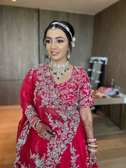 A full-length shot of the bride in her magnificent red lehenga. The entire look is a perfect blend of tradition and modern bridal elegance.