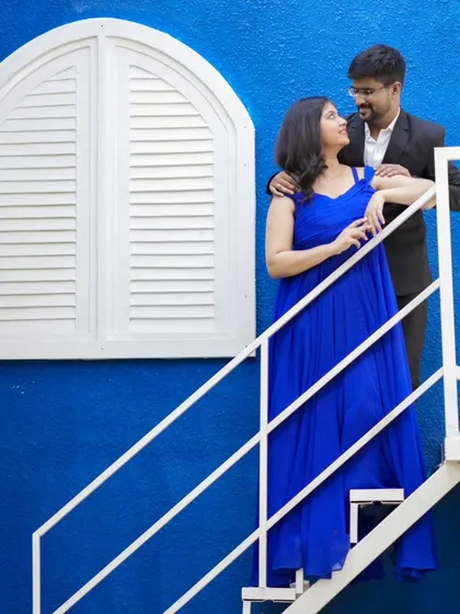 A lovely pose on a white staircase against a vibrant blue wall. This is one of the many colorful and unique sets we offer.