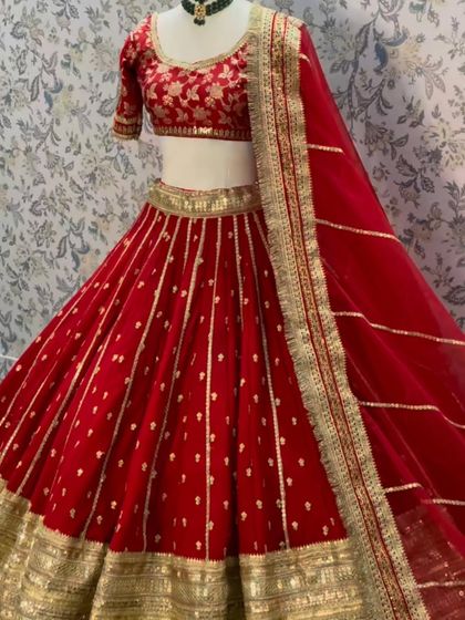 A simple and elegant red lehenga with vertical gold stripes and a matching embroidered blouse. This outfit is available for rent.