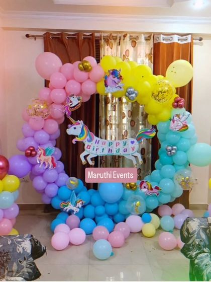 A simple and sweet unicorn-themed balloon arch for a home party. The rainbow-colored balloons and unicorn cutouts create a cheerful and magical photo spot.