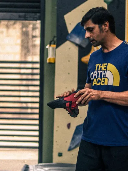 Getting the right gear is your first step. An instructor explains the importance of proper climbing shoes, which are crucial for grip and effective footwork on the bouldering wall.