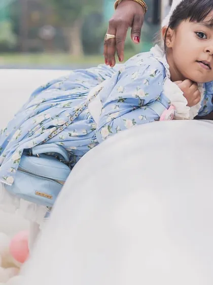 A toddler safely enjoying the edge of the ball pit, with soft, cushioned walls ensuring a secure play environment.