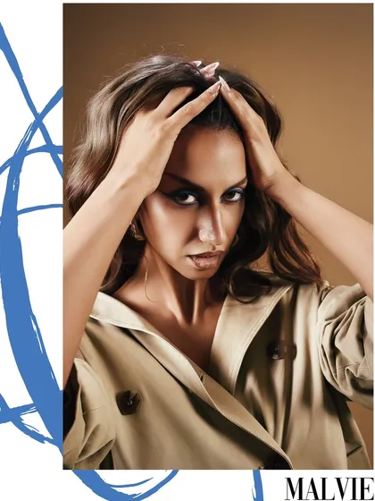 A direct and powerful shot from the same Malvie series, with the model's intense gaze framed by her hands and bold graphic elements.