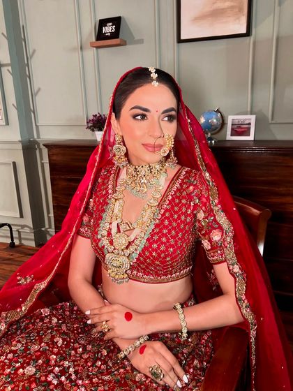 The complete traditional red bridal ensemble. Every detail, from the makeup to the jewellery, comes together to create a look of pure elegance.