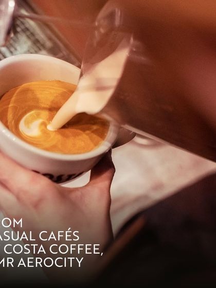 A barista pours latte art at Costa Coffee. This attention to detail reflects the quality of experience you can expect at all our business-friendly cafes, making every coffee break a small pleasure.