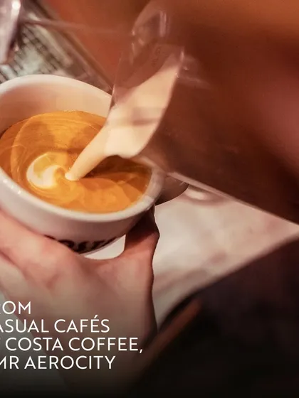 A barista pours latte art at Costa Coffee. This attention to detail reflects the quality of experience you can expect at all our business-friendly cafes, making every coffee break a small pleasure.