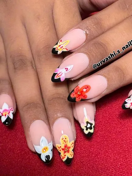 A bold and beautiful design featuring colorful 3D flowers on sharp, black-tipped nails. The contrast between the dark tips and the bright, blooming flowers gives this set a unique attitude.