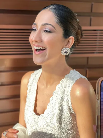 A joyful, candid moment, with the sleek bun keeping the look polished and elegant.