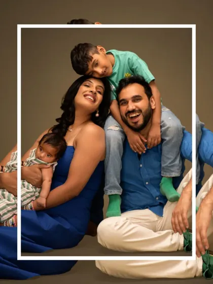 A fun and relaxed family portrait with an older child on dad's shoulders and mom holding the newborn. We love capturing the playful dynamics of a growing family.