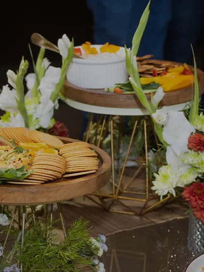 Tiered stands displaying fresh crackers and dips, artfully arranged with floral accents to enhance the visual appeal of the food.