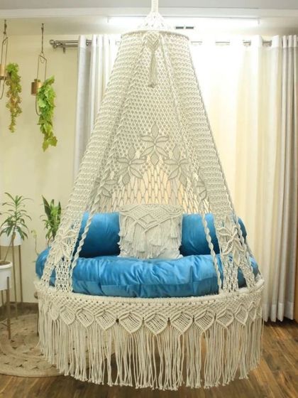 A classic white macrame swing paired with bright blue cushions. This shows how you can easily change the look of your swing just by swapping out the pillows.