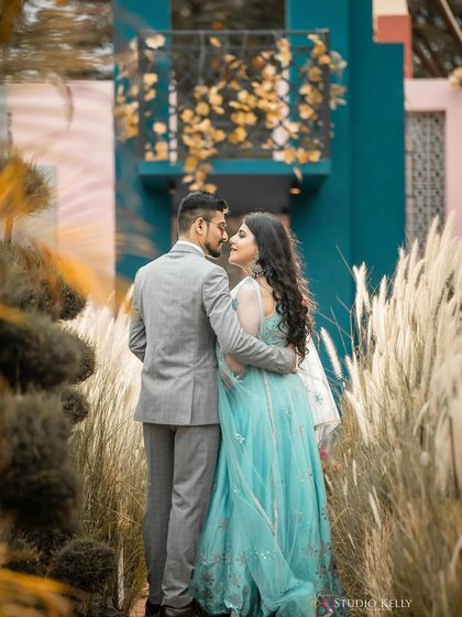 A dreamy, romantic shot in a field of tall grass. The makeup is soft and ethereal, matching the beautiful outdoor setting.