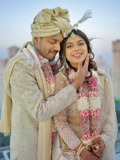 A tender moment on the wedding day, with the groom gently caressing the bride's face. The soft light and genuine smiles make this a truly romantic portrait.