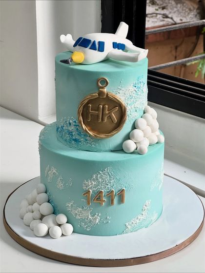 Taking celebrations to new heights. This custom aviation-themed cake was crafted for someone whose journey is as special as their milestone, featuring a handcrafted airplane and personalized initials.
