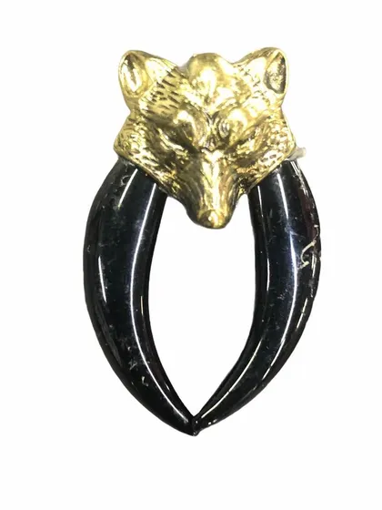 A variation of our popular wolf brooch, this version features a gold-tone sculpted wolf head with two polished black tusks. The high contrast makes it a bold and striking accessory.