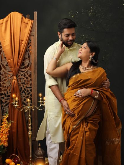 Draped in heritage, glowing with motherhood. This intimate couple portrait in traditional wear captures a moment of quiet love and affection.