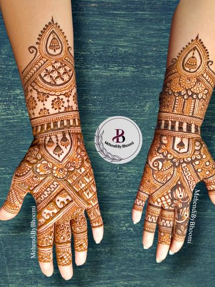 This Indian mehendi design is full of traditional charm. It features temple bells, elephants, and intricate patterns that flow from the arm down to the fingertips.