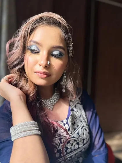 This angle shows off the beautiful silver jewelry and the soft waves in the hair, which perfectly complement the cool-toned eye makeup.