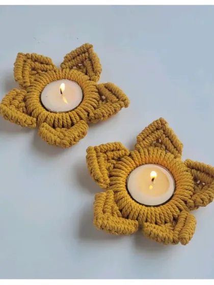 A top-down view of the mustard-colored tealight holders, showing the neat, star-shaped knot work.