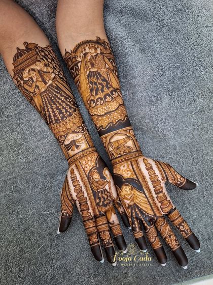 A heavy bridal design featuring a bride in her doli on one arm and a couple portrait on the other, both rendered with incredible detail and artistry.