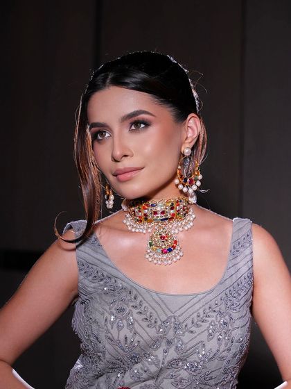 A portrait showcasing the soft evening glam. The makeup enhances her features beautifully, and the multi-colored jewelry adds a playful yet elegant touch.