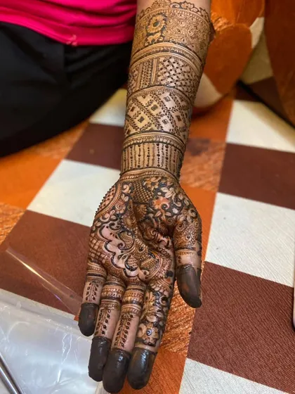 A close-up of one hand from the engagement design, showing the intricate line work and shading. The solid fingertips provide a classic finish to the modern patterns.