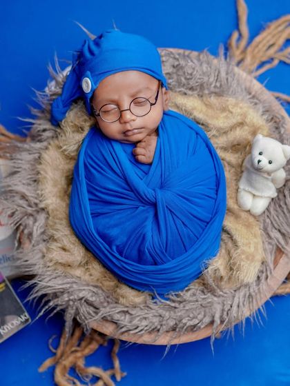 Dreaming of magical spells. This little one, with their tiny glasses and nest-like bed, looks like they've come right out of a storybook.