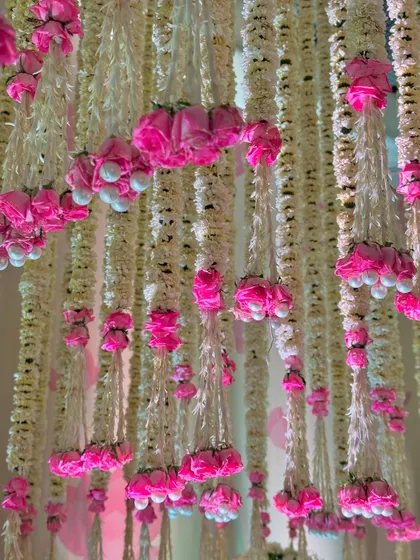 A close-up of the delicate, cascading floral strings. We use a combination of tuberoses and pink roses to create these fragrant, beautiful ceiling installations. 🌸