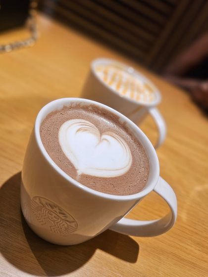 Pause, sip, and savor the moment. A hot chocolate with beautiful latte art from Starbucks is the perfect way to take a breather on your journey.