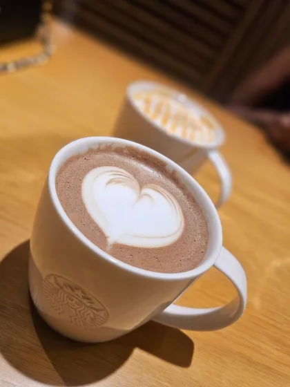 A beautifully prepared cup of hot chocolate with latte art from our Starbucks, proving that a highway break can still be a moment of indulgence.