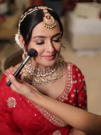 The final touch of blush for bride Krusha. This moment captures the care and detail that goes into perfecting every bridal look.