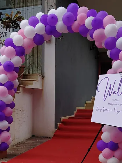 Creating a grand welcome for an engagement ceremony. This setup featured a custom balloon arch in the couple's chosen colors, a red carpet, and personalized welcome signage to greet their guests.