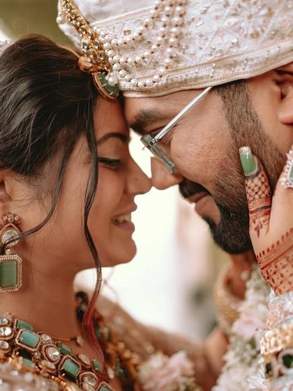 An intimate portrait of the couple, their foreheads touching, eyes closed in a moment of pure connection.