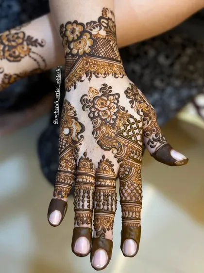 An Indo-Arabic design with a mix of floral and paisley motifs. The patterns are intricate and flow beautifully from the fingers to the wrist.