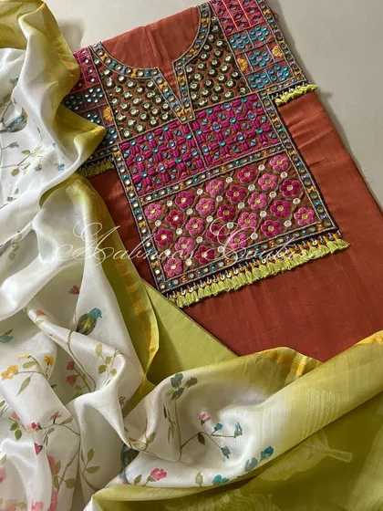This composition shows the elegant drape of the dupatta, highlighting the beautiful contrast between the earthy rust kurta and the fresh, light-colored painted fabric.