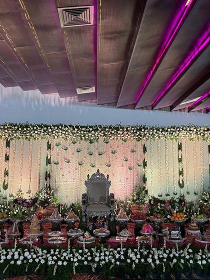 A wide view of the white floral stage with purple ceiling lights.