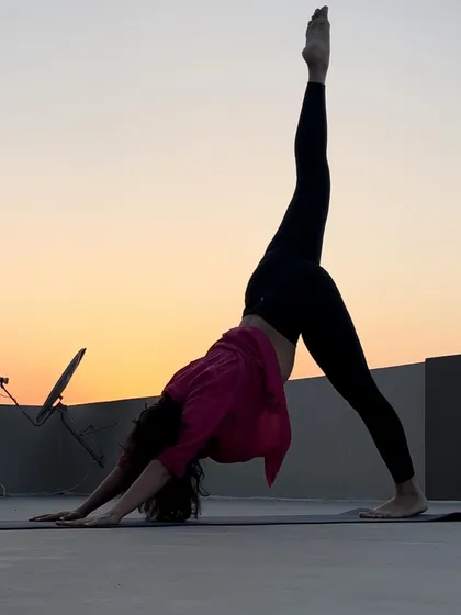A three-legged downward dog against the sunset. This pose is a great way to open the hips and stretch the hamstrings before moving into deeper poses.
