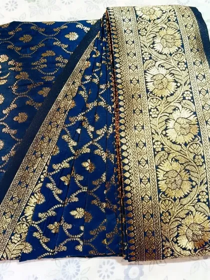 A gorgeous royal blue and gold Banarasi saree, pre-pleated and folded for a wedding. This is how your saree arrives, compact and ready for you to look your best without any stress.