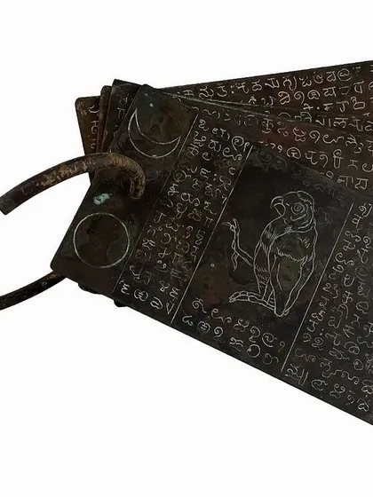 'Atlas 159', a copper sculpture with patination by Pushpamala N, resembling ancient palm-leaf manuscripts.