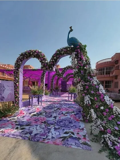 For a unique and royal touch, I created this stunning wedding entrance featuring a peacock made entirely of purple and white flowers. The floral arches and matching printed aisle create a cohesive and unforgettable welcome for your guests.