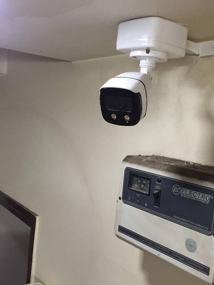 A bullet camera installed indoors, next to a power stabilizer. A good choice for monitoring long corridors or entryways.