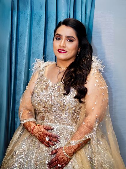 A close-up of the reception glam. The red lip is the perfect statement against the glittering gold of her outfit, creating a look of pure opulence.