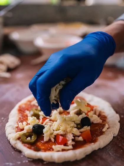 Even the food gets a pet-friendly twist! A chef is seen here preparing fresh, wood-fired pizzas, a favorite among guests at our relaxed and inclusive brunch events.