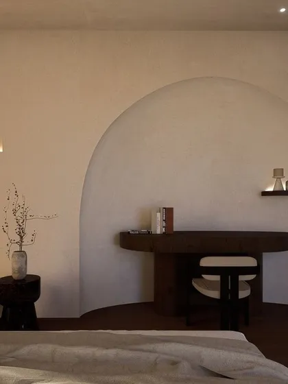 A signature arch creates a cozy nook for a study desk within the bedroom. This architectural detail adds softness and character while defining a functional zone within the serene space.